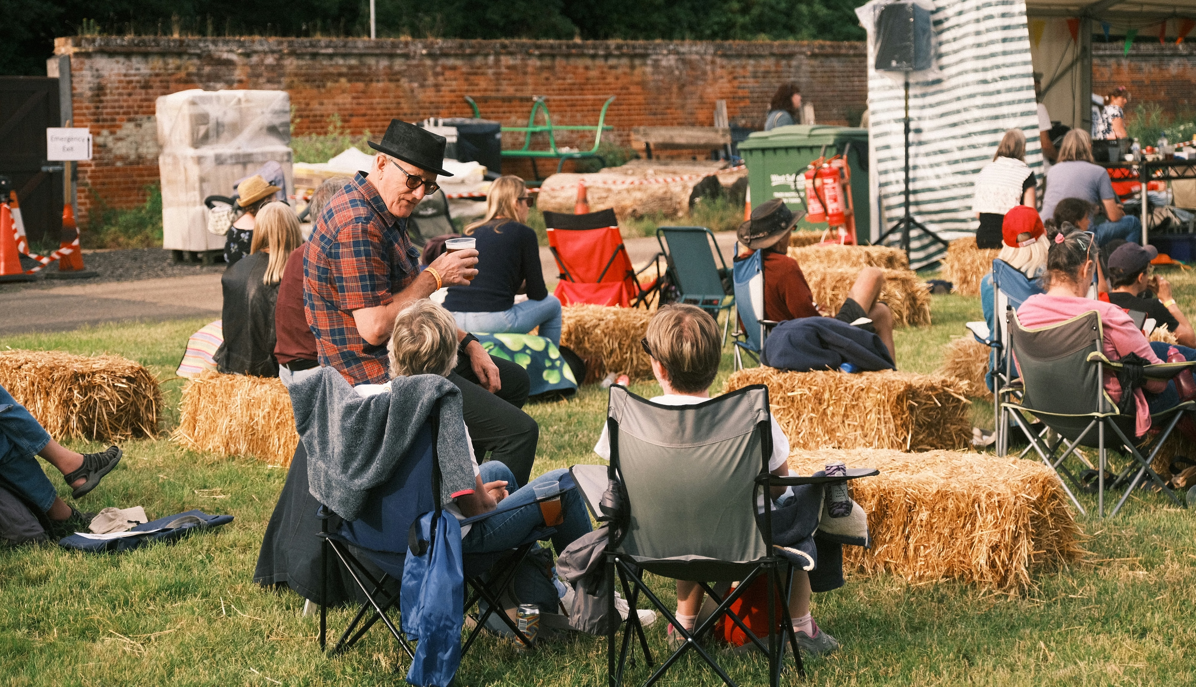Older person talks to two younger persons outside at an event